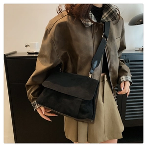 Détail d'un grand sac cabas en toile noir avec bandoulière large et rabat minimaliste