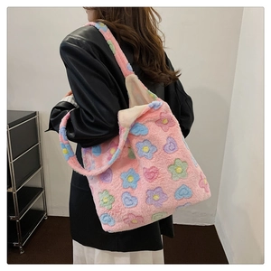 Detailed close-up of a large pink plush tote bag with colorful flower and heart patterns