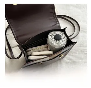 Detail view of the interior compartment showing capacity for a wallet, phone, and umbrella