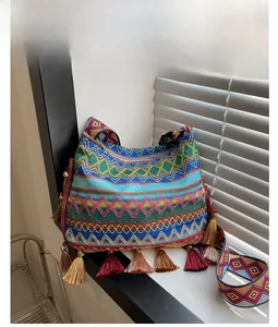 Close-up of bohemian woven tote bag featuring colorful geometric patterns and fringe