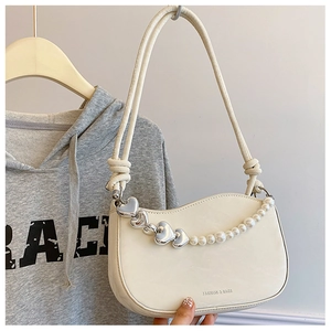 Detail of off-white leather shoulder bag with wavy edge and pearl heart chain strap