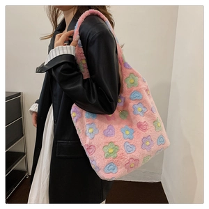 Detailed view of pink plush tote bag featuring colorful flower and heart patterns