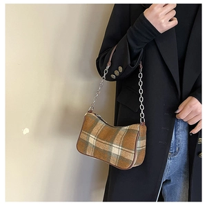Close-up of vintage plaid underarm bag with silver chain and brown leather strap details