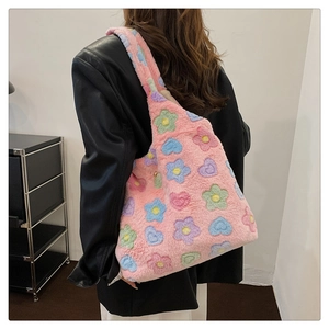 Detailed side view of a pink fluffy tote bag featuring colorful flower and heart patterns
