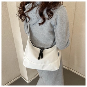 Close-up of white waterproof Oxford nylon crossbody bag with black sport label on a model
