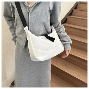 Detail of white nylon crescent bag with wide black strap and Sport side label