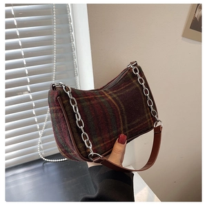 Detail of red and green plaid shoulder bag with silver chain and leather strap accents