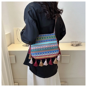 Detail of bohemian tote bag with woven geometric patterns and long colorful fringes