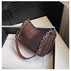 Detail of vintage plaid underarm bag with brown leather strap and silver chain link