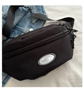 Detail of black nylon chest bag with FANYISSA brand label and adjustable strap