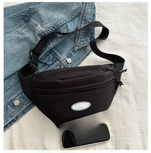 Detailed view of black nylon waist bag with dual zippers and adjustable buckle strap