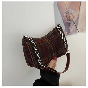 Detail of retro plaid underarm bag with metal chain and wool texture fabric