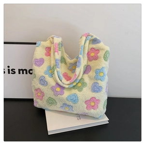 Close-up of the soft plush fabric featuring colorful floral and heart patterns on the tote bag