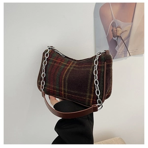 Detail of plaid baguette bag with vintage tartan pattern and silver chain strap detail