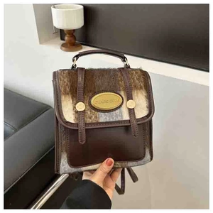 Detail of vintage mini backpack showing brown PU leather and faux fur texture with metal logo