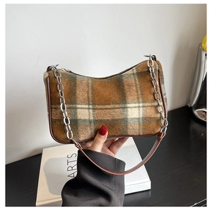 Detail of vintage plaid underarm bag with brown leather trim and silver metal chain link