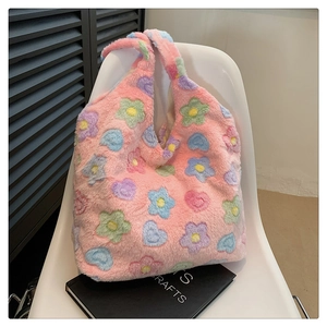 Detail of soft plush pink tote bag with colorful floral patterns on a white chair