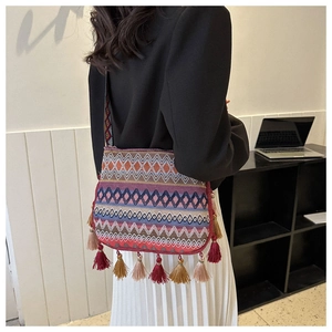 Close-up of bohemian woven tote bag with colorful geometric patterns and long fringes
