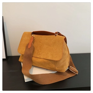 Détails du sac bandoulière en daim jaune moutarde avec ferrures dorées et sangle marron