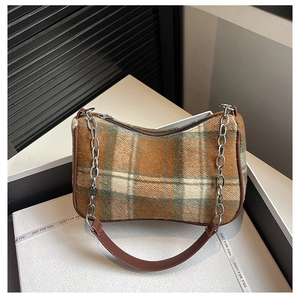 Detail of plaid texture and silver metal chain on a brown faux leather shoulder bag