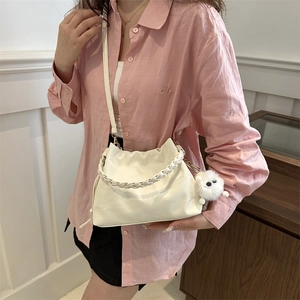 Sac seau beige chic avec poignée tressée, breloque en peluche et bandoulière réglable