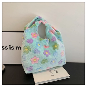 Close-up of soft blue plush tote bag featuring colorful pastel floral and heart patterns