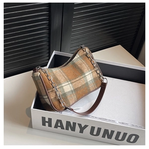 Close-up of retro plaid underarm bag in brown tweed with chain and leather strap
