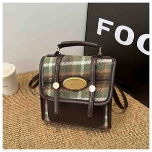 Detail of vintage mini backpack with green plaid wool and brown leather patchwork design