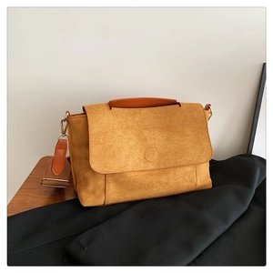 Détail du sac bandoulière en daim jaune moutarde avec large sangle et poignée