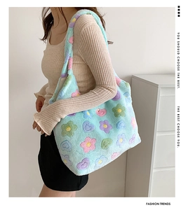 Close-up of light blue plush tote bag featuring colorful flower patterns and soft texture