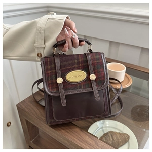Close-up of retro plaid mini bag with gold metal plate and brown PU leather detail