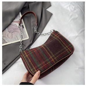 Detail of vintage plaid underarm bag with wool texture and brown leather trim
