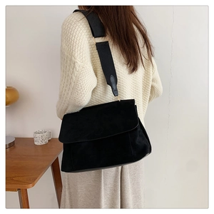 Grand sac fourre-tout noir en toile avec large bandoulière porté par un mannequin