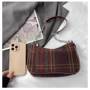 Flat lay of vintage plaid baguette bag with silver chain and brown leather strap