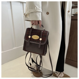 Detailed shot of retro brown leather and plaid stitching on a versatile mini backpack