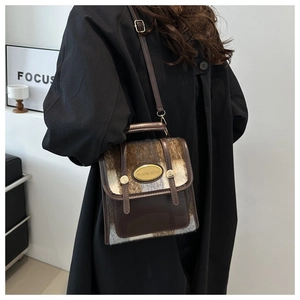 Detail of vintage mini crossbody bag with dark brown faux leather and plaid fabric texture