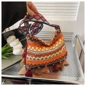 Detail of bohemian woven tote bag with fringe tassels and colorful geometric patterns