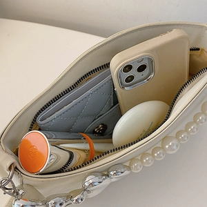 Chic beige underarm bag with pearl chain strap showing inner storage capacity