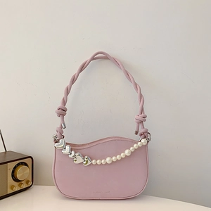 Pink heart-buckle underarm bag with pearl chain and woven handle in retro aesthetic