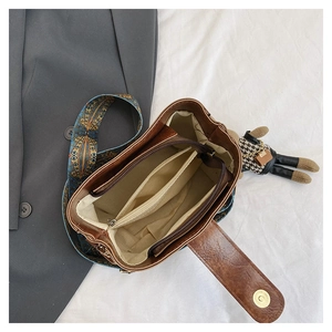 Detail view of brown vintage bucket bag interior with compartments and wide ethnic strap