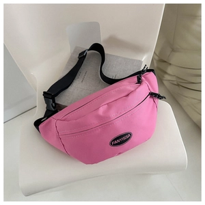 Detailed shot of pink canvas fanny pack on a chair showing the adjustable black strap and logo