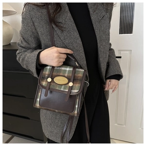 Detail of vintage patchwork mini bag with brown leather and green plaid fabric