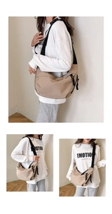 Detail view of khaki nylon hobo bag featuring black woven zipper pull and wide shoulder strap