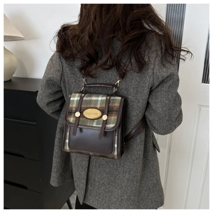 Detail of vintage plaid mini backpack on model showing strap and fabric texture
