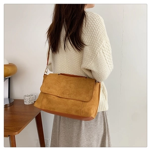 Sac bandoulière en daim marron dans un cadre de vie, idéal pour le trajet quotidien chic