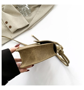Detail of khaki twill crossbody bag with textured fabric and knotted shoulder strap