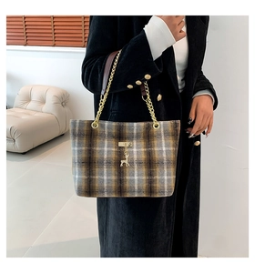 Detail of plaid wool tote bag featuring gold chain strap and cute deer charm pendant