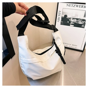 Detail of white nylon dumpling bag with adjustable black strap and woven cord zipper pull