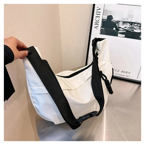 Detail of white nylon bag showing adjustable black shoulder strap and plastic buckle closure