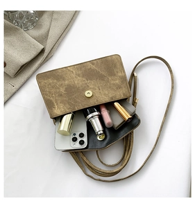 Internal view of a brown vintage crossbody bag showing smartphone and lipstick storage